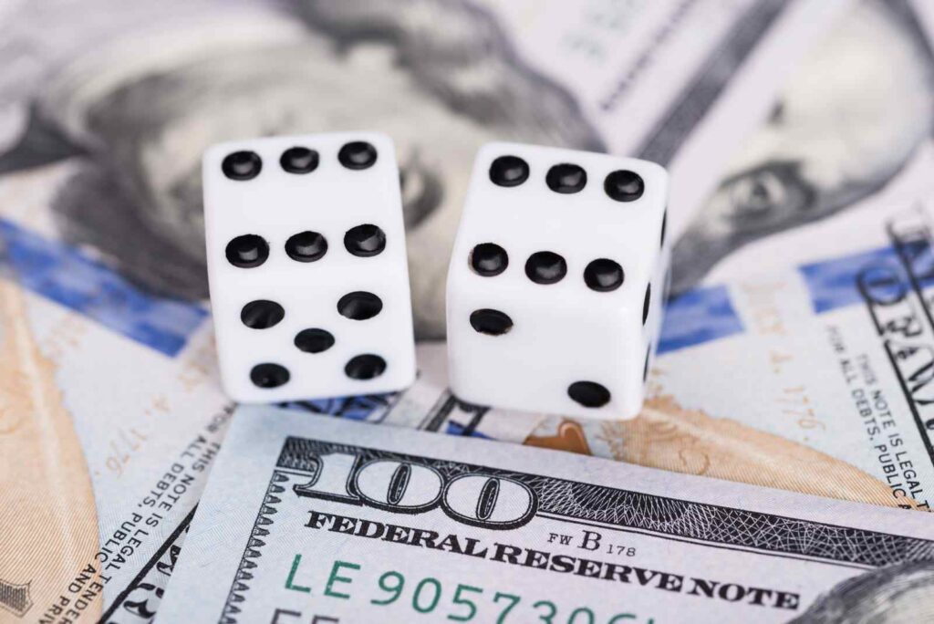 Dice on dollar bills, representing TMBTQ Law's website services and expertise in financial legal matters.